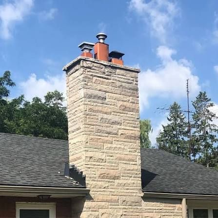 Stone chimney fitted with twin metal caps