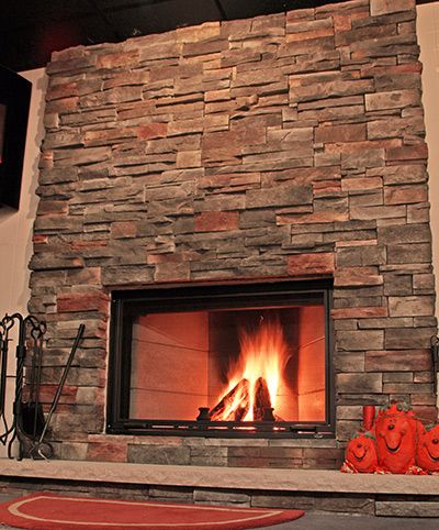 Stacked stone fireplace with a strong fire burning